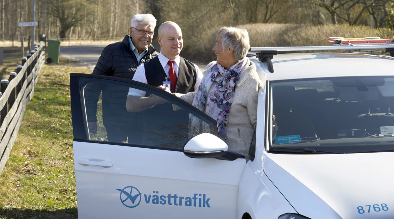 Äldre par talar glatt med en taxichaufför.