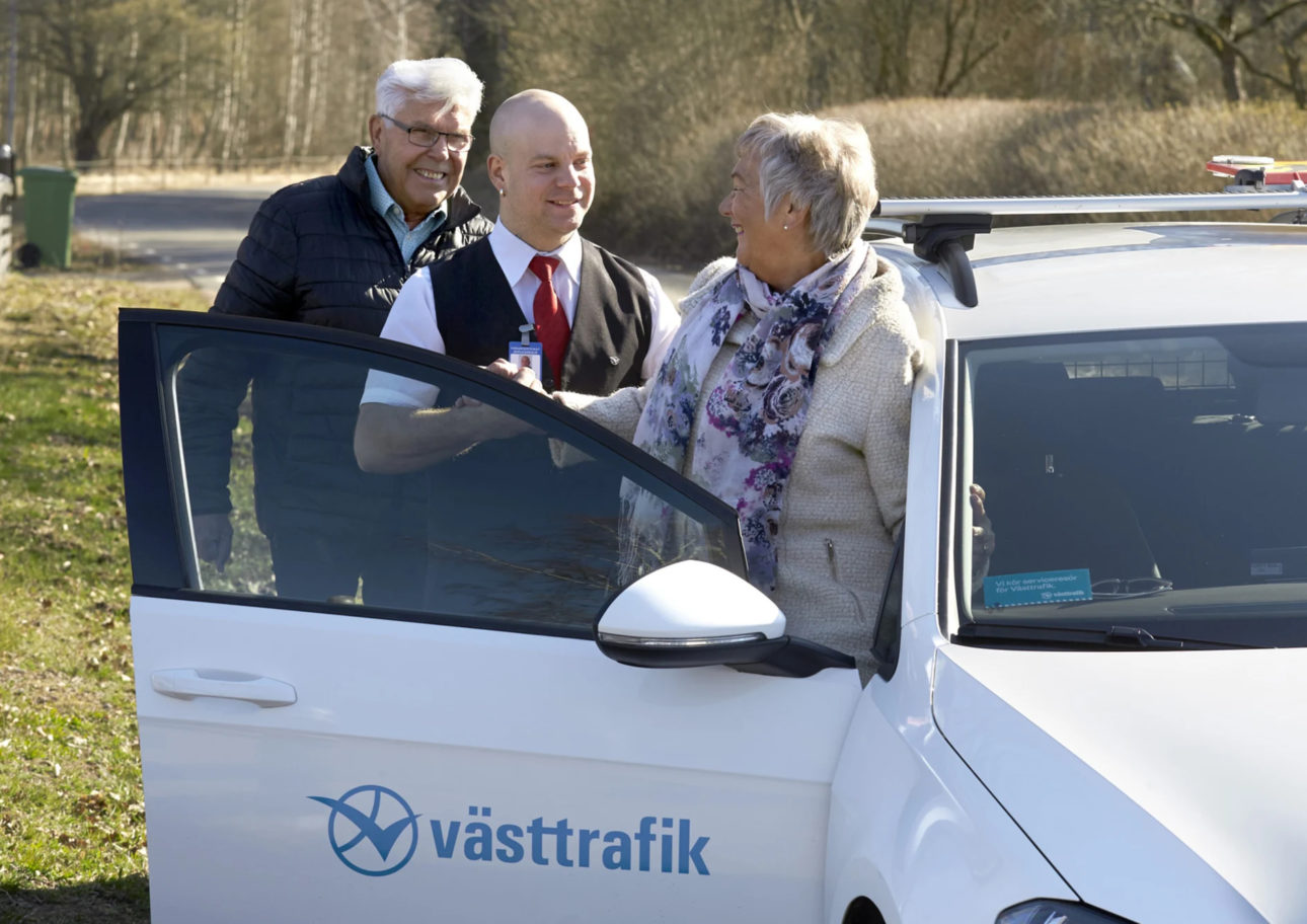 Äldre par talar glatt med en taxichaufför.