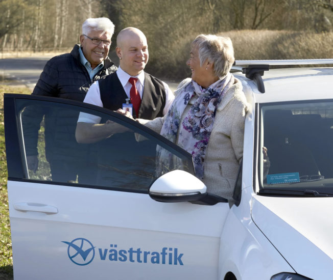 Äldre par talar glatt med en taxichaufför.