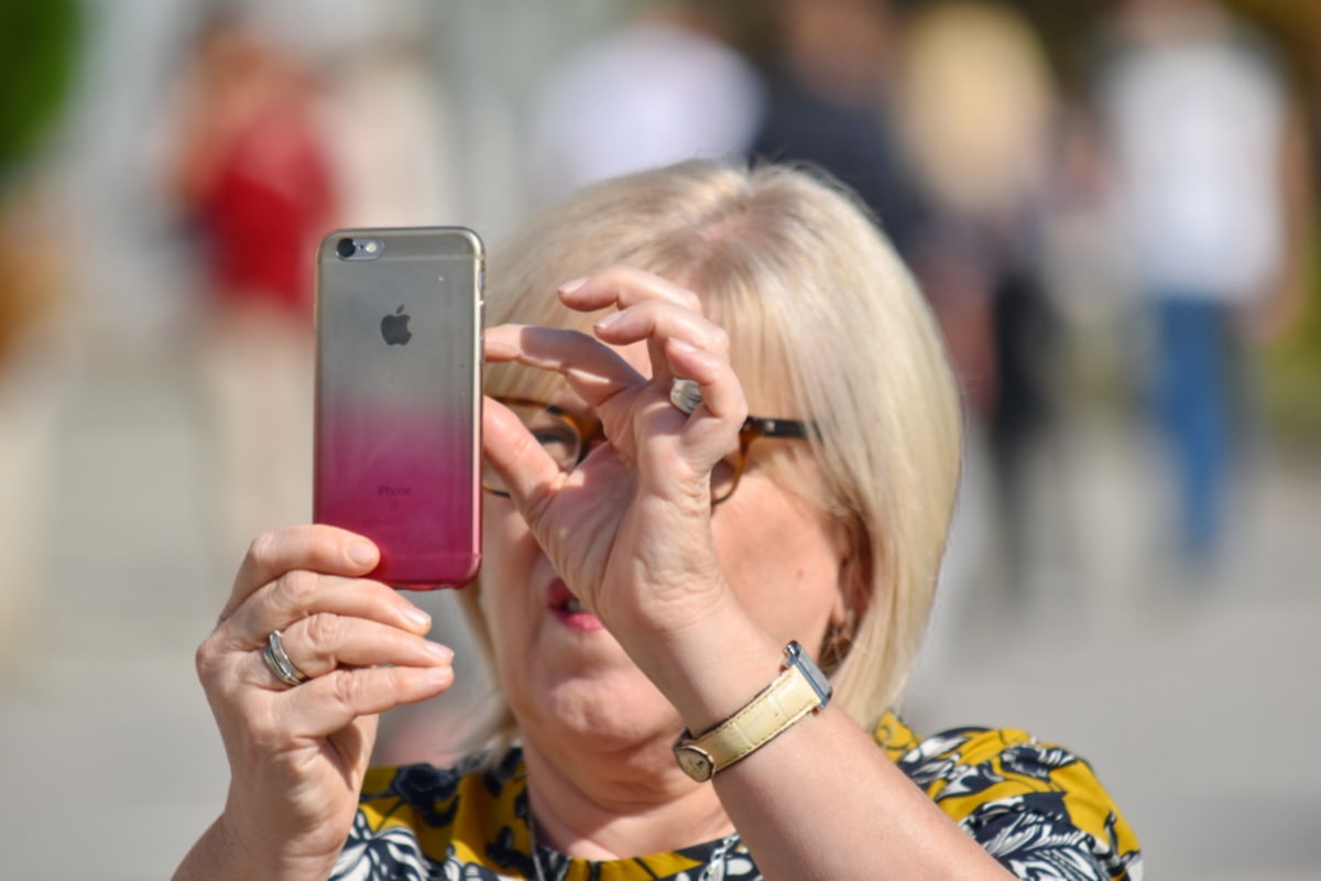 Kvinna tar foto med sin mobiltelefon