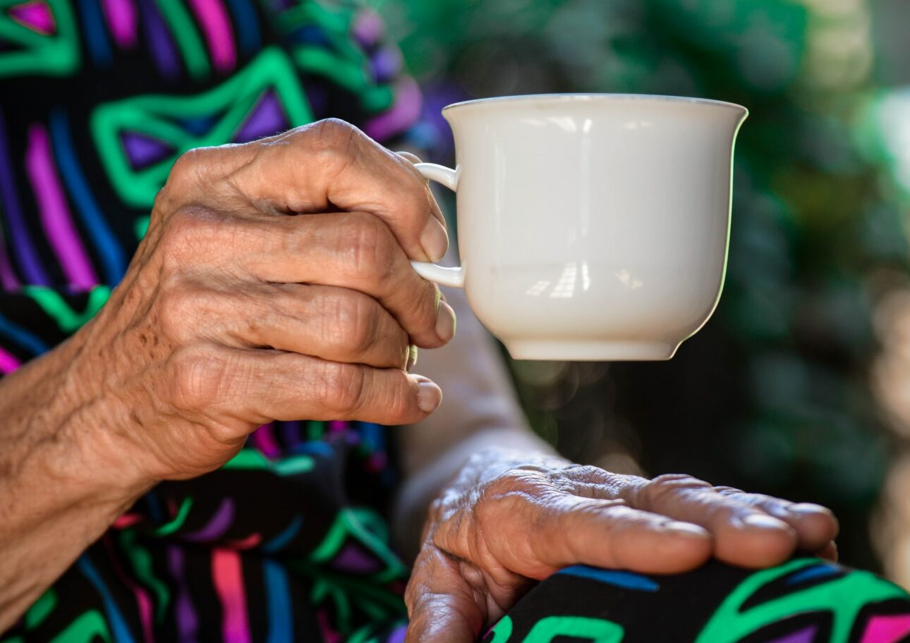 Äldre kvinna med en kopp i handen
