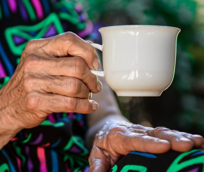 Äldre kvinna med en kopp i handen