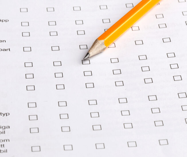 En blyertspenna ligger på en enkät med frågor och svarsrutor att kryssa i.
