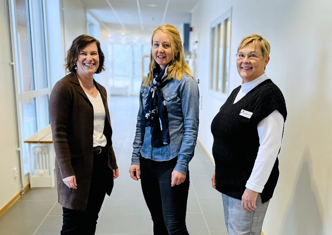Alexandra Björck, Mialinn Arvidsson Lindvall och Outis Blohm står i en vit korridor på ett äldreboende.