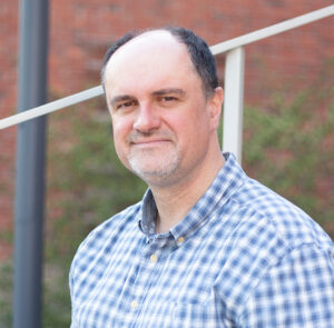 Porträttbild på man som sitter i en trappa