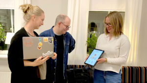 Forskarna Elin Holmström, Anders Helin och Hanna Rönntoft visar det digitala verktyget. På skärmen kan bilder "hissas eller dissas" i användarens profil. Foto: RISE