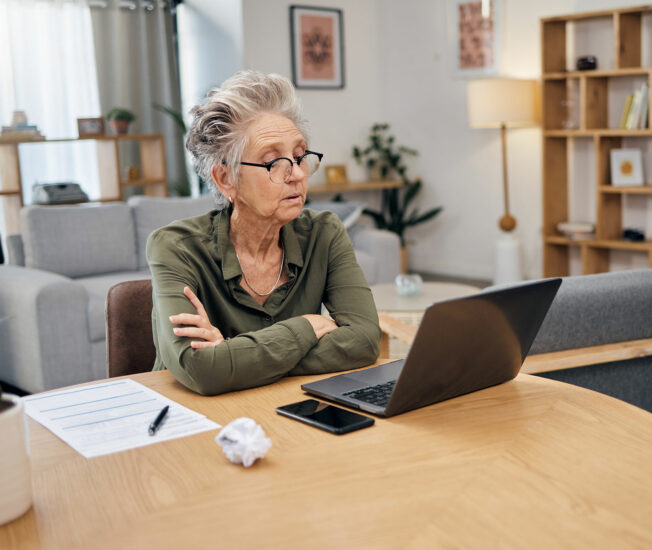 Äldre kvinna sitter och tittar på en datorskärm