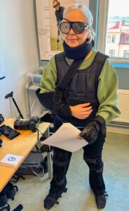 Äldre i Centrums chefredaktör iklädd en väst, armskydd, svartade glasögon och stela knäskydd