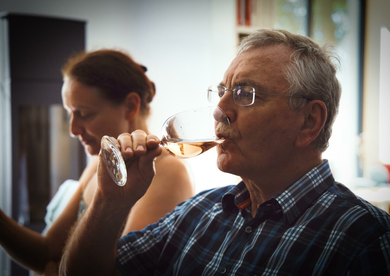 Äldre man dricker ett glas vin