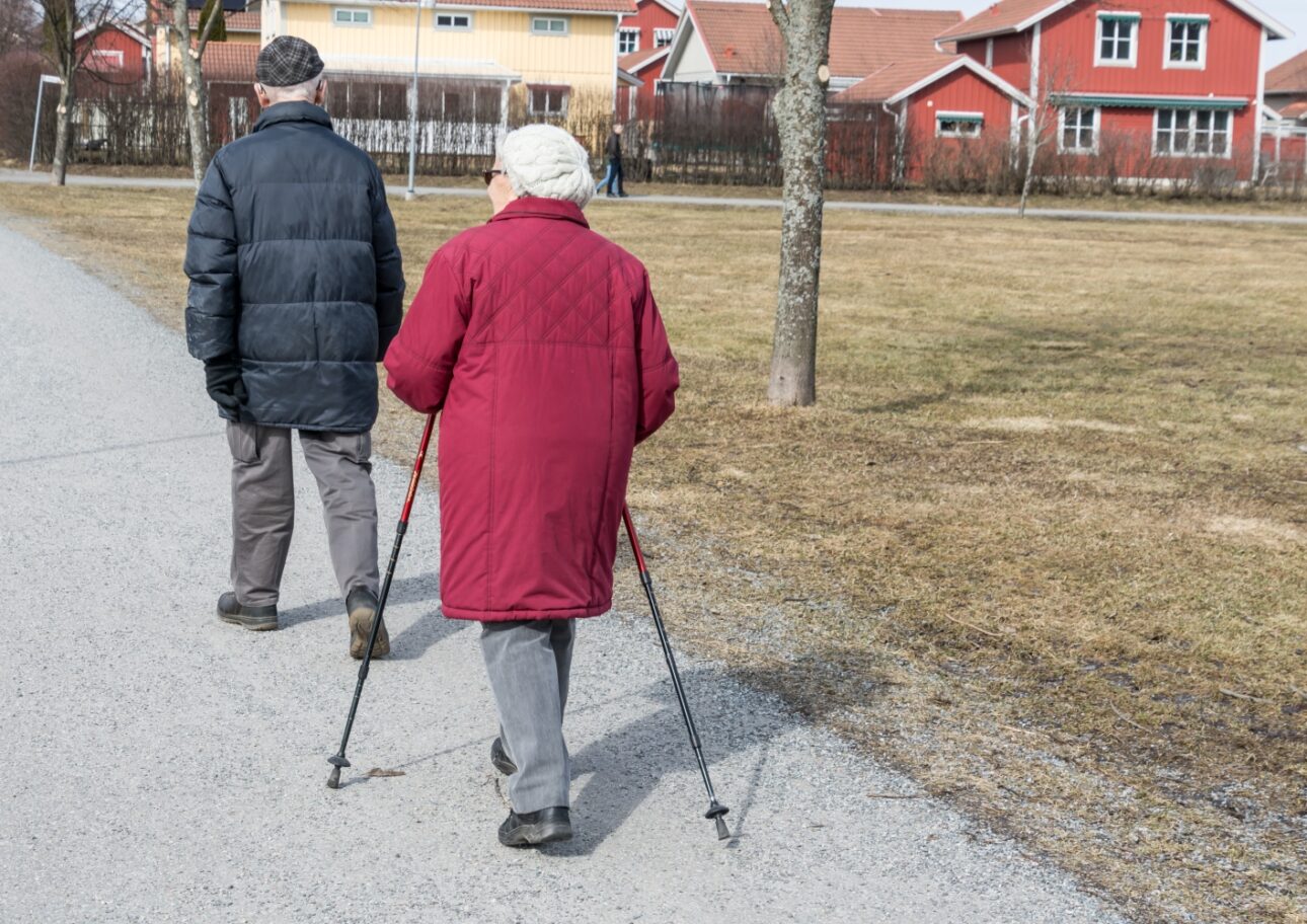 Äldre par promenerar utomhus