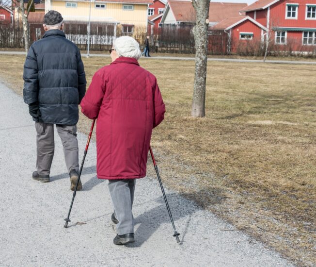 Äldre par promenerar utomhus