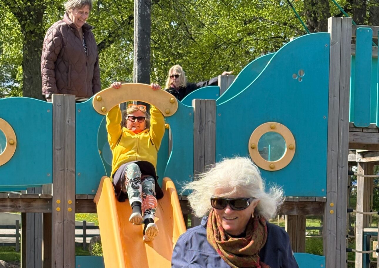 Äldre kvinnor klättrar på rutschkana