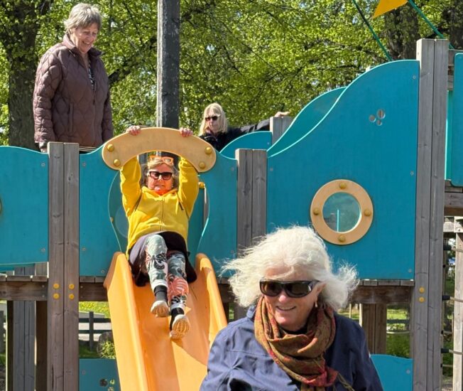 Äldre kvinnor klättrar på rutschkana