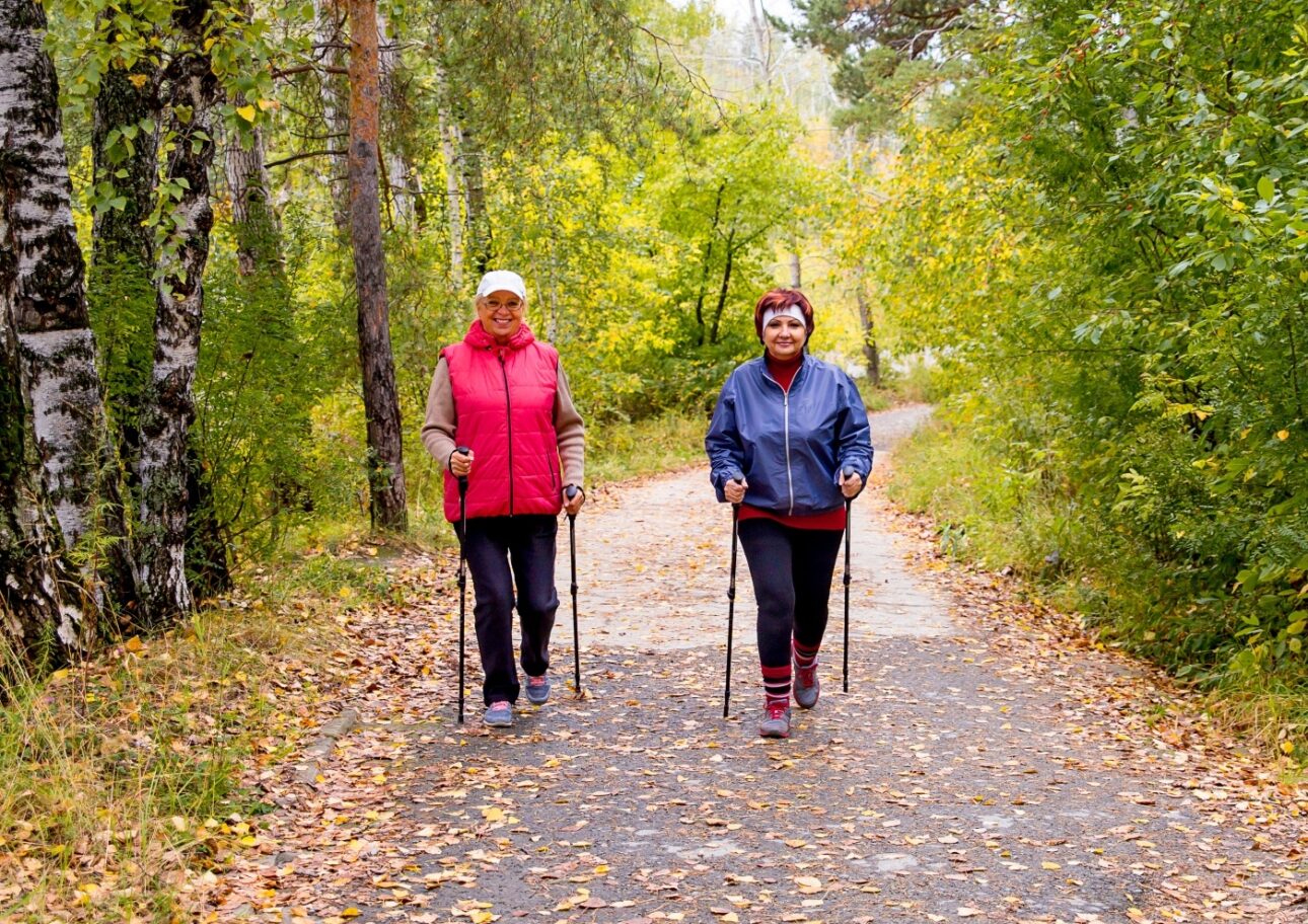 Två äldre kvinnor promenerar på en stig