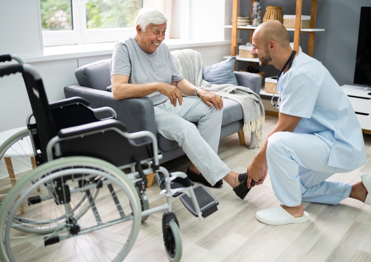 Äldre man får hjälp av en sjuksköterska i hemmet