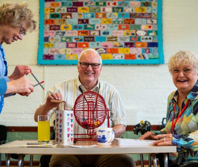 Äldre personer samlade kring ett spel