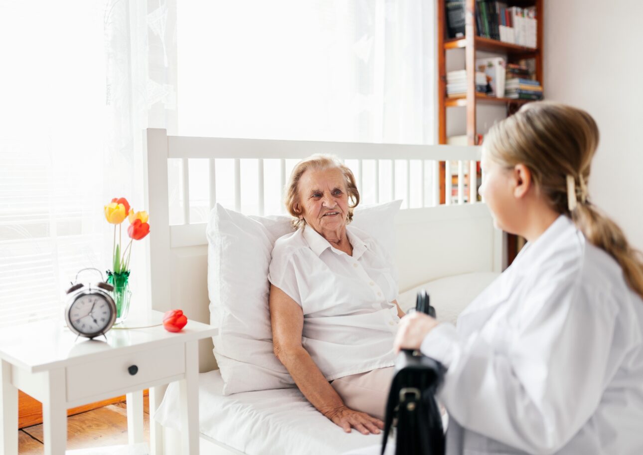 Äldre kvinna får besök av vårdpersonal i hemmet