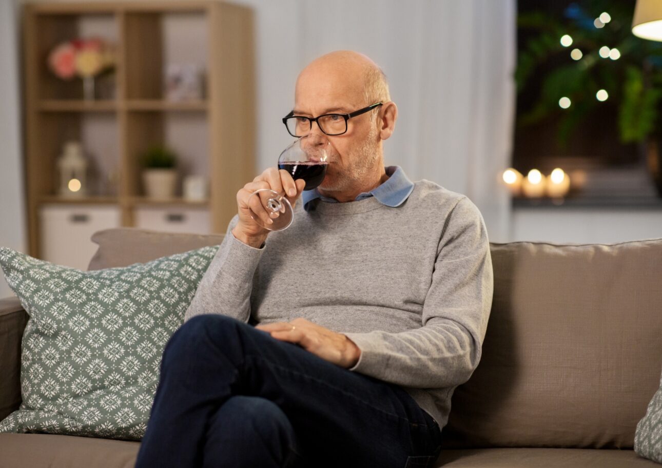 Äldre man dricker vin