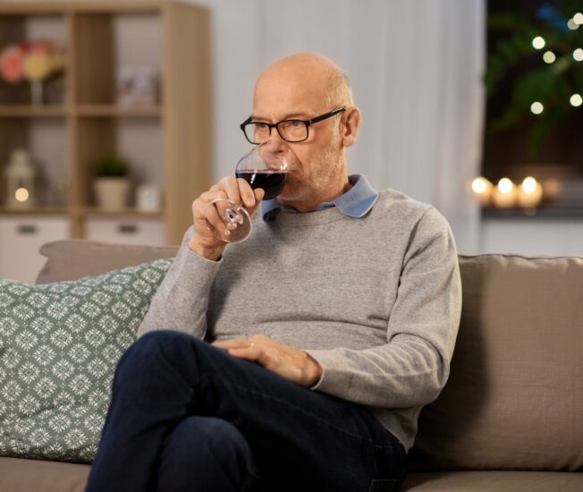 Äldre man dricker vin