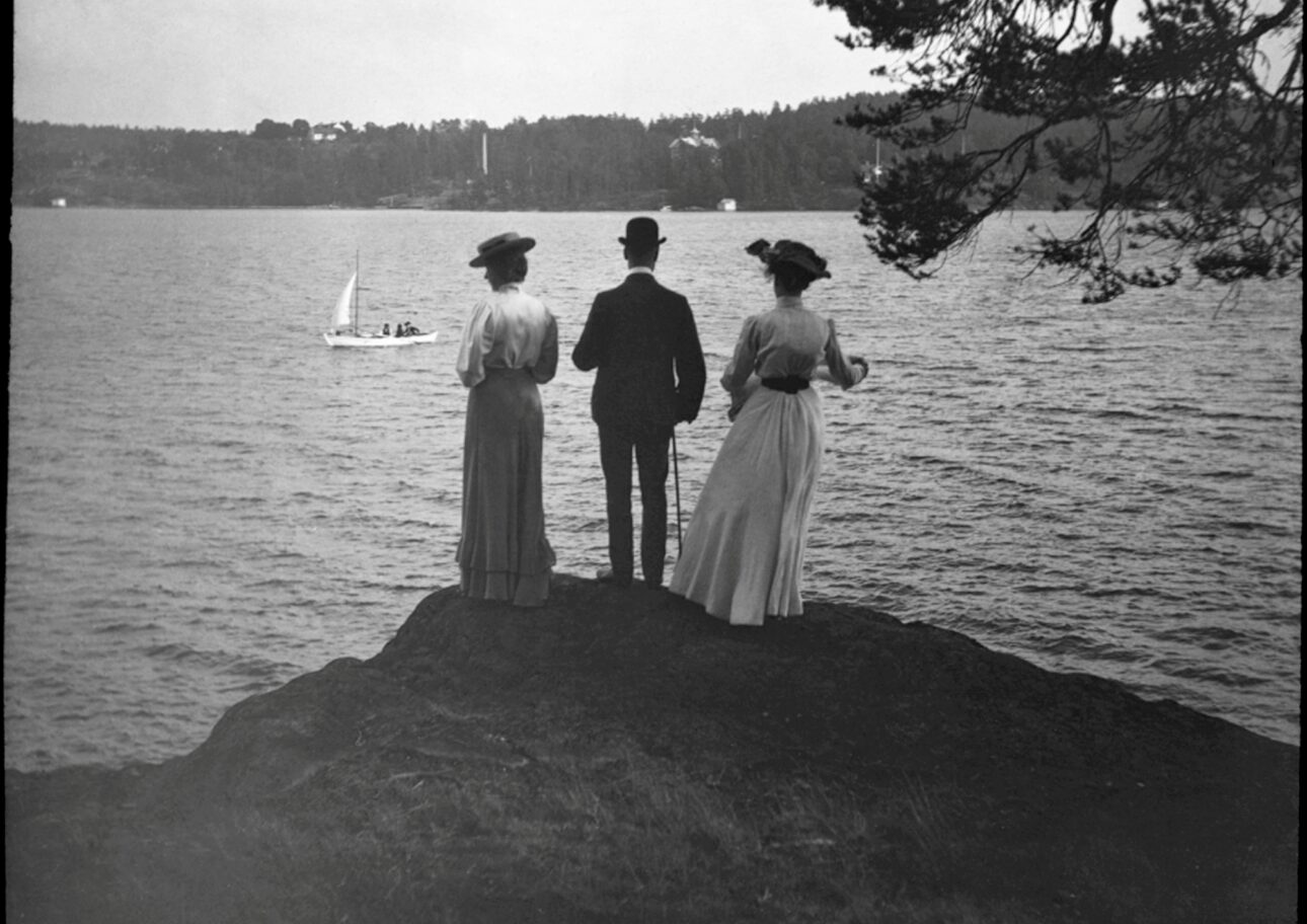 Gammalt foto av en man och två kvinnor på en klippa