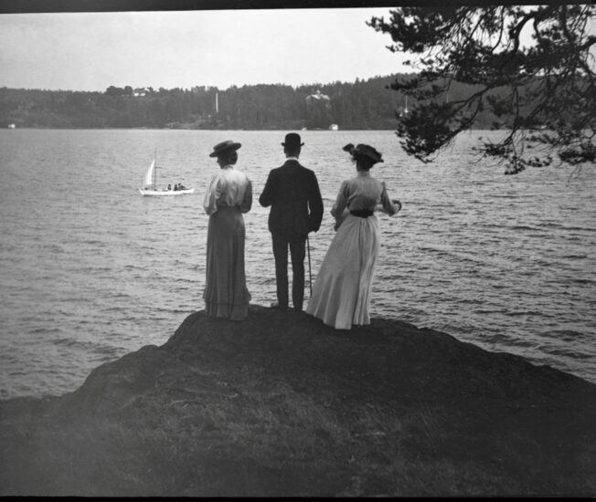 Gammalt foto av en man och två kvinnor på en klippa